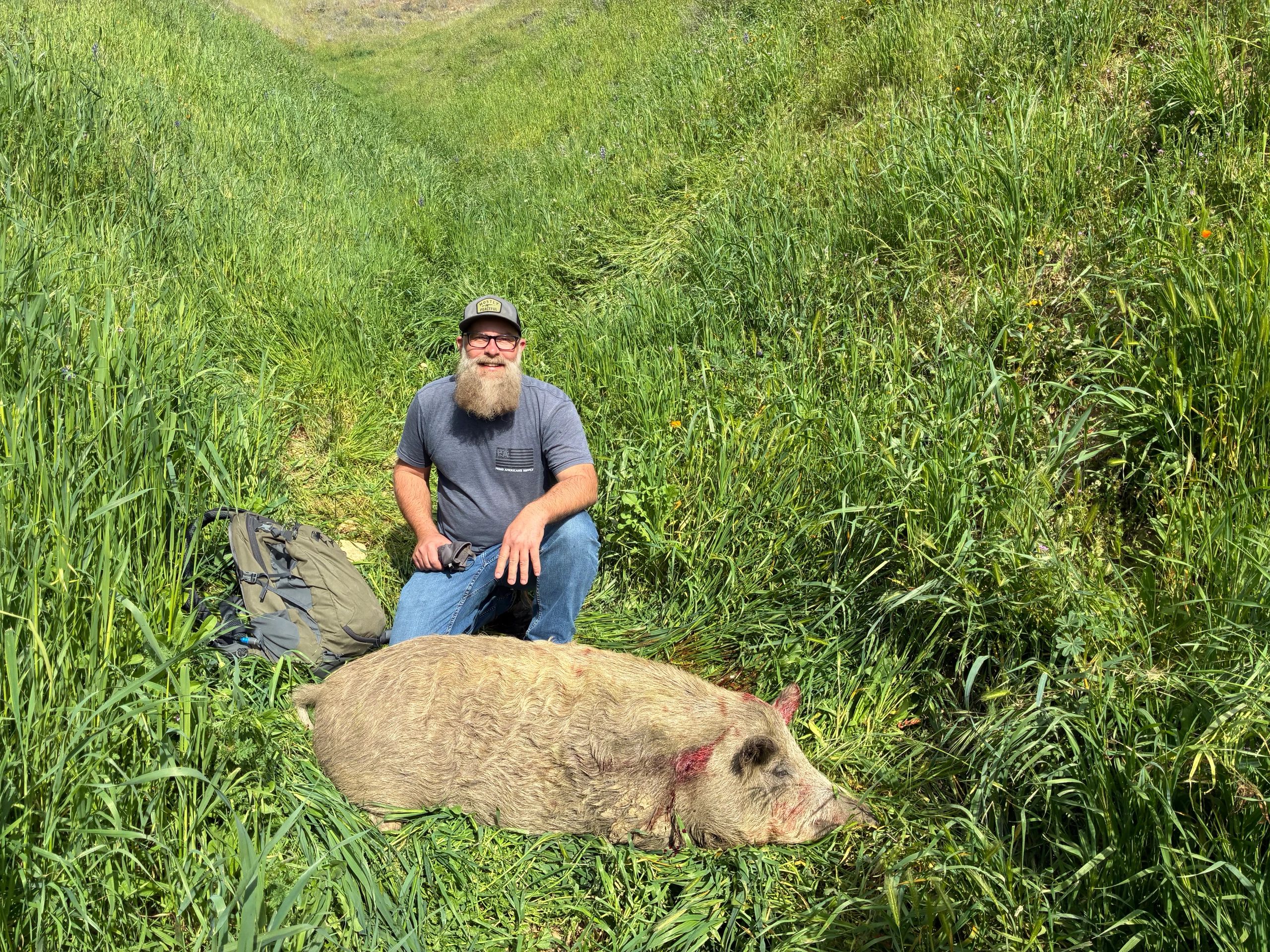 Bearded hunter with harvested wild boar